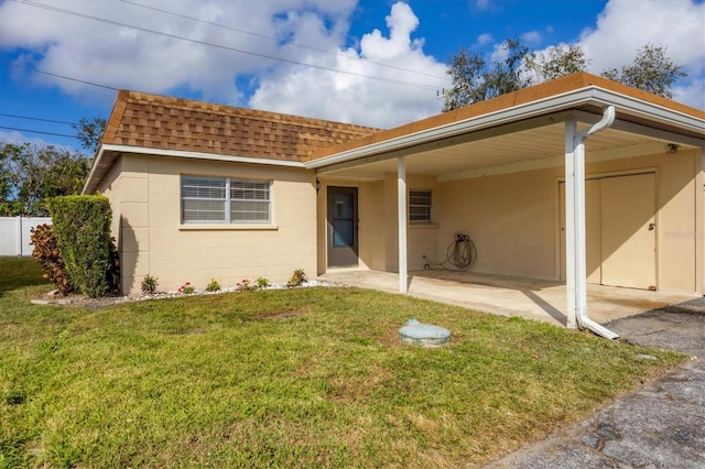 view of front facade with a front lawn and a carport