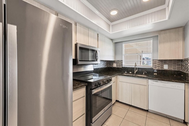 kitchen featuring a raised ceiling, sink, backsplash, dark stone counters, and stainless steel appliances