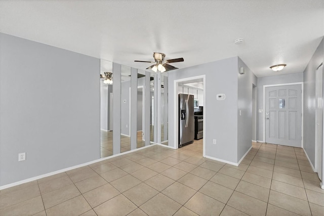empty room with light tile patterned floors and ceiling fan