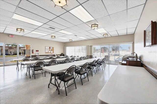dining area featuring a drop ceiling and a healthy amount of sunlight