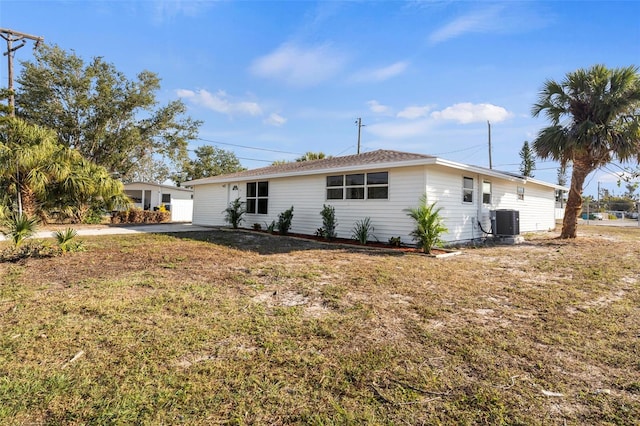 exterior space with central AC unit and a yard