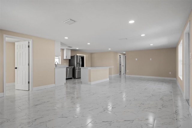 unfurnished living room featuring sink