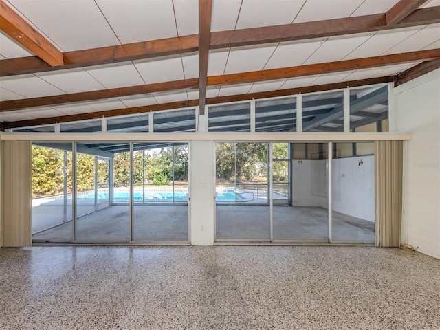 interior space with plenty of natural light and vaulted ceiling with beams