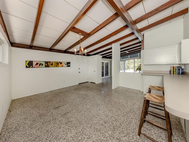 living room featuring beam ceiling and a notable chandelier