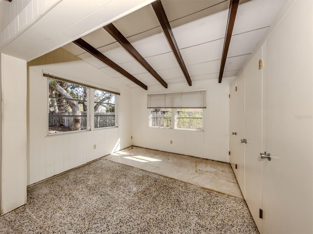 unfurnished room featuring lofted ceiling with beams