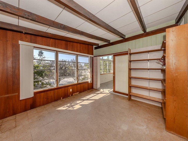 interior space featuring wooden walls and beam ceiling