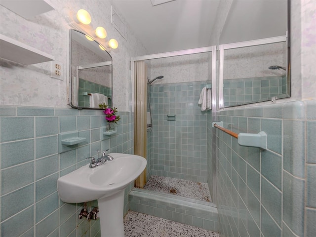 bathroom featuring tile walls, sink, and tiled shower