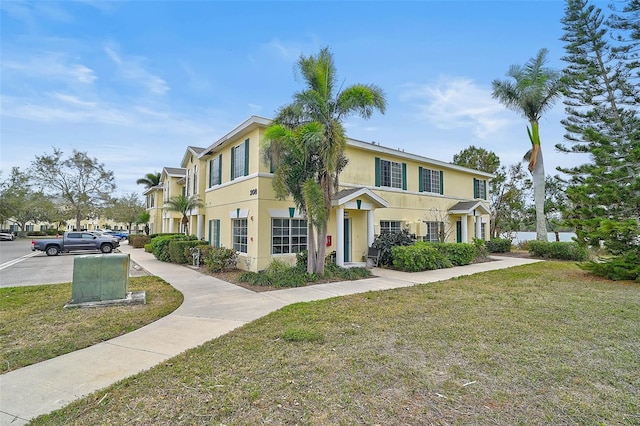 view of property with a front lawn and stucco siding