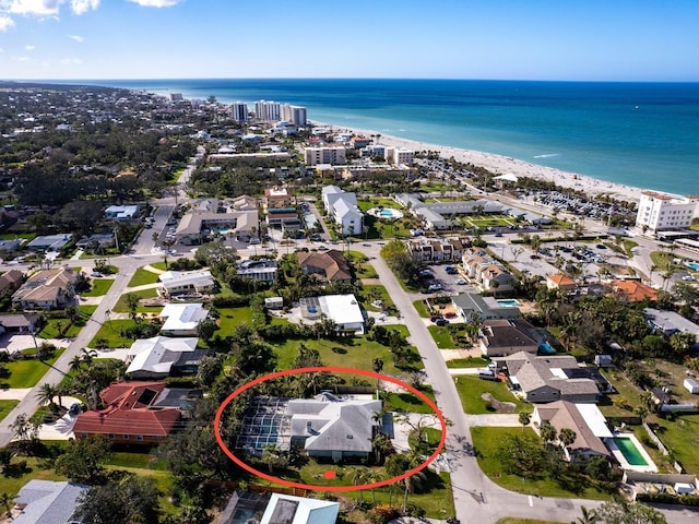 aerial view with a water view and a beach view