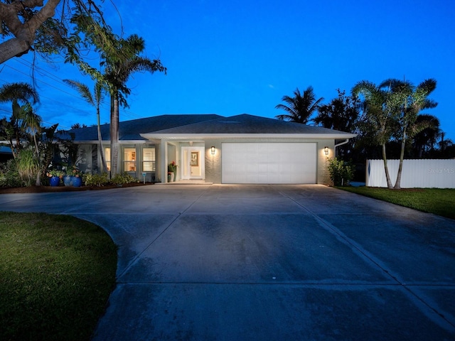 view of front of property featuring concrete driveway, fence, an attached garage, and stucco siding