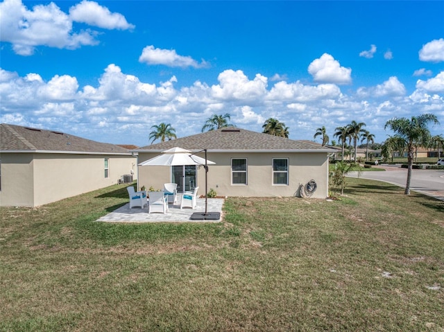 rear view of house featuring a yard and a patio area