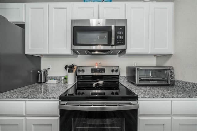 kitchen with white cabinetry, range with electric cooktop, and light stone counters