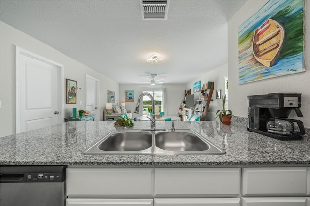 kitchen with sink, a textured ceiling, dark stone countertops, dishwasher, and white cabinets