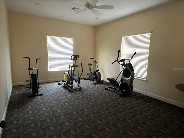 workout area featuring ceiling fan and dark carpet