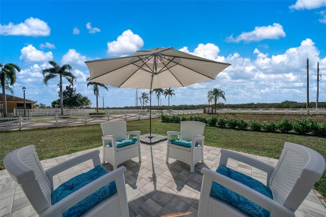 view of patio / terrace with fence and a rural view