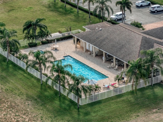 pool featuring a patio area, a fenced backyard, and a yard