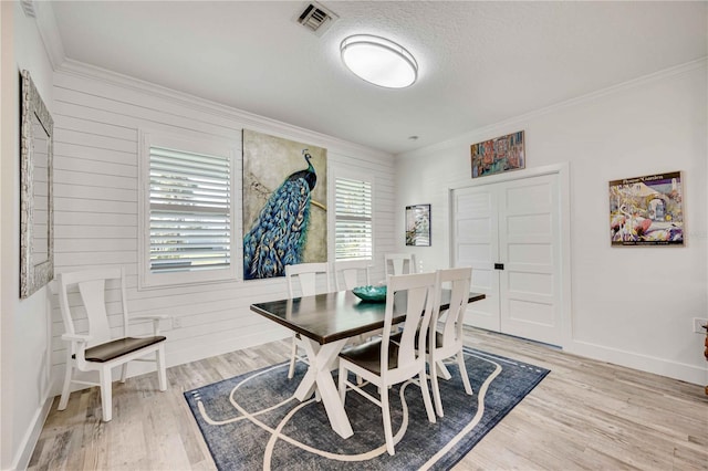 dining area with hardwood / wood-style flooring, crown molding, and a textured ceiling