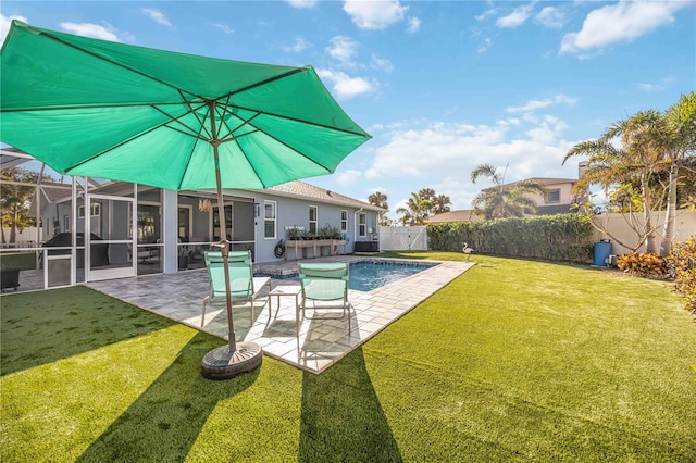 view of pool with a patio, glass enclosure, and a lawn