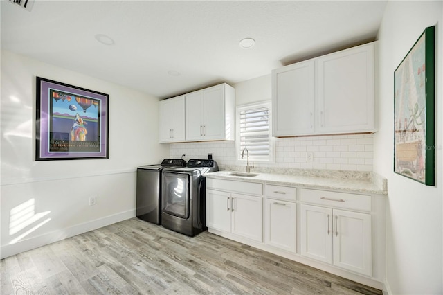 432 W Gate Dr, Venice, FL 34285 - laundry room featuring a sink, cabinet space, separate washer and dryer, light wood-style flooring, and baseboards