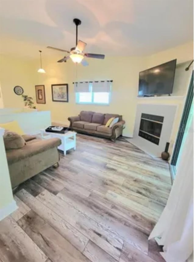 living room featuring ceiling fan and light wood-type flooring