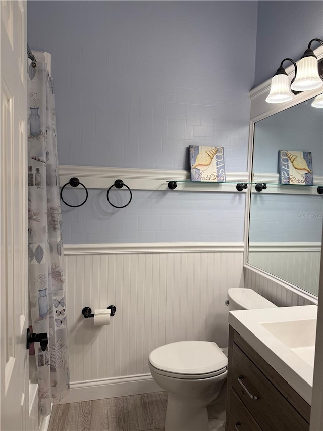 bathroom with a shower with shower curtain, vanity, toilet, and hardwood / wood-style floors