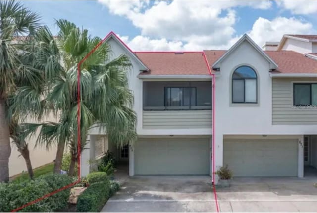 625 Duchess Blvd, Dunedin, FL 34698 - view of front of house with a garage, stucco siding, concrete driveway, and roof with shingles