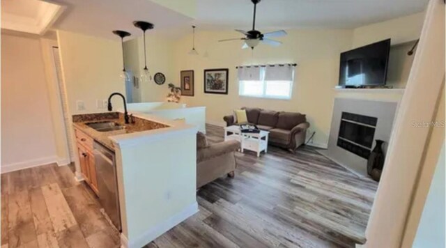 625 Duchess Blvd, Dunedin, FL 34698 - kitchen with wood finished floors, a fireplace, ceiling fan, dishwasher, and hanging light fixtures