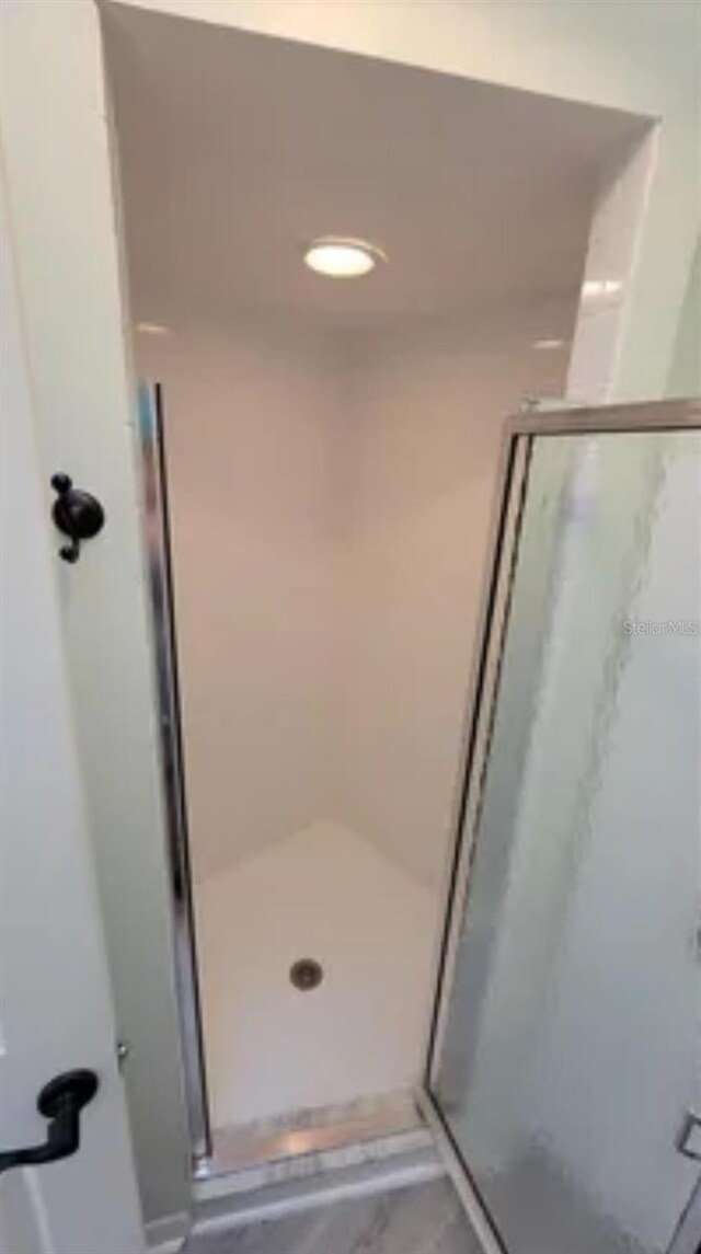 625 Duchess Blvd, Dunedin, FL 34698 - bathroom with a stall shower and marble look tile flooring