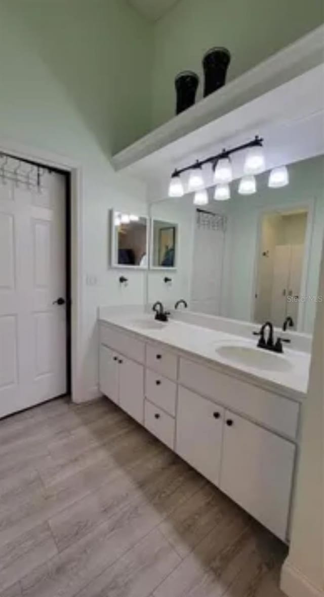 625 Duchess Blvd, Dunedin, FL 34698 - full bath with double vanity, wood finished floors, and lofted ceiling