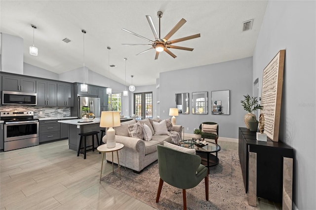 living room featuring ceiling fan, high vaulted ceiling, and light wood-type flooring