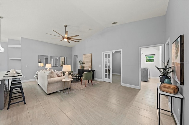 living room featuring vaulted ceiling, french doors, and ceiling fan