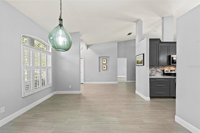 kitchen featuring decorative backsplash, appliances with stainless steel finishes, vaulted ceiling, and hanging light fixtures