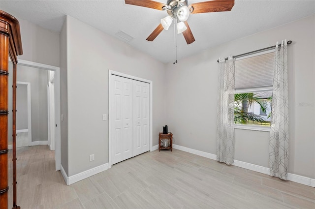 unfurnished bedroom featuring ceiling fan and a closet