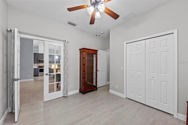 unfurnished bedroom with a closet, ceiling fan, and french doors