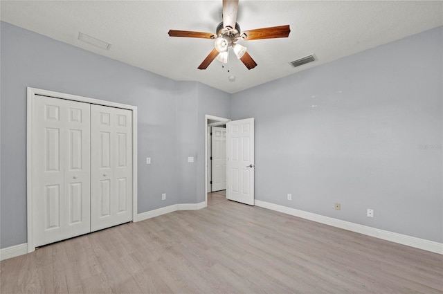 unfurnished bedroom featuring ceiling fan, light hardwood / wood-style floors, a closet, and a textured ceiling