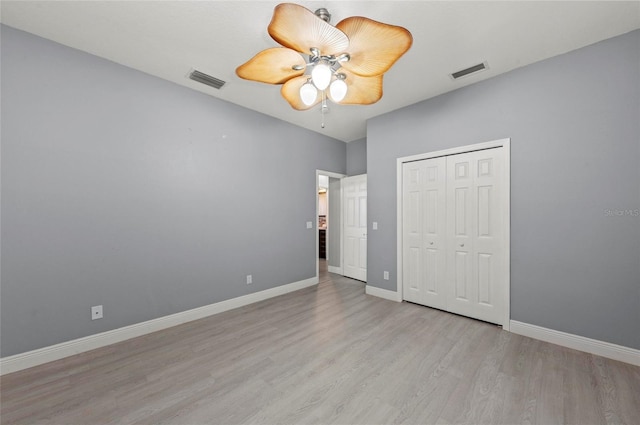 unfurnished bedroom featuring light hardwood / wood-style flooring, a closet, and ceiling fan