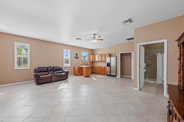 tiled living room featuring a textured ceiling and ceiling fan