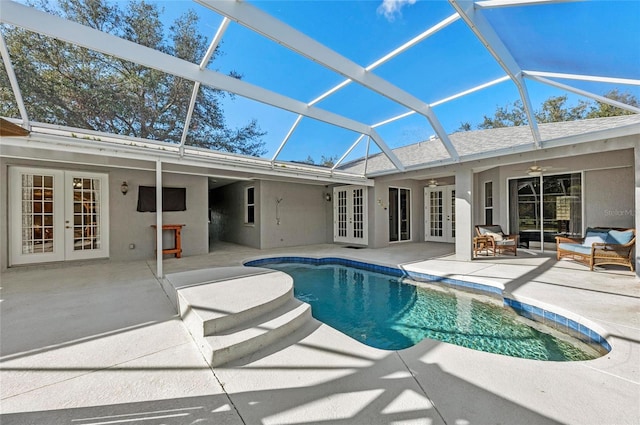 view of swimming pool with french doors, ceiling fan, glass enclosure, and a patio