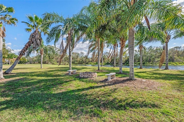 view of home's community featuring a water view, a yard, and an outdoor fire pit