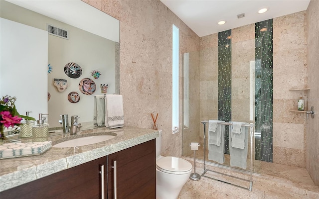 bathroom featuring vanity, toilet, and a shower with shower door