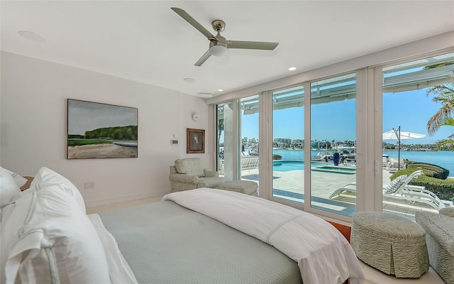 bedroom with access to exterior, ceiling fan, and a water view