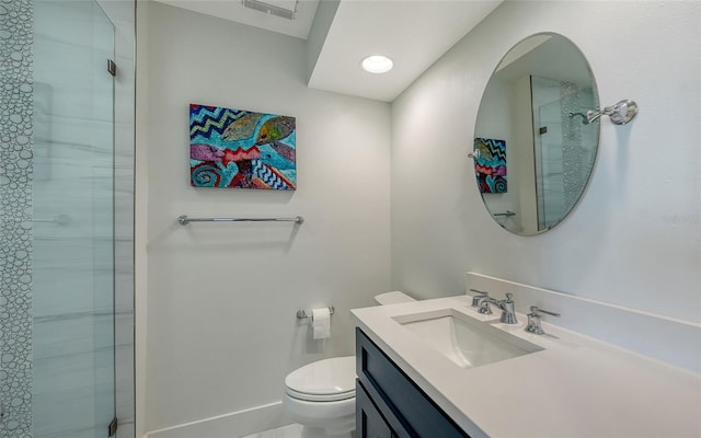 bathroom featuring vanity, toilet, and a shower with door