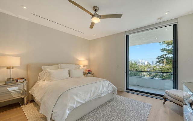 bedroom with expansive windows, ceiling fan, light hardwood / wood-style flooring, and access to outside