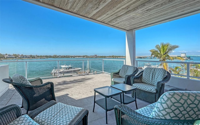 view of patio with an outdoor living space, a balcony, and a water view