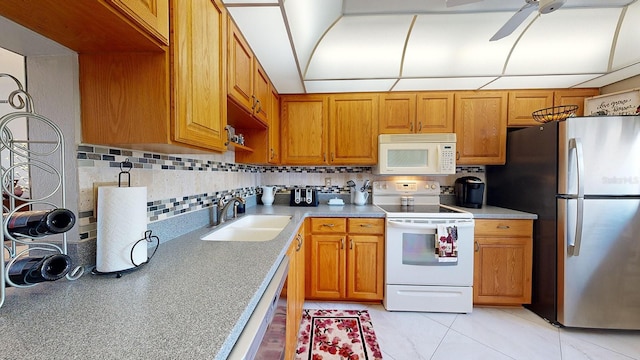 kitchen featuring ceiling fan, white appliances, sink, and backsplash