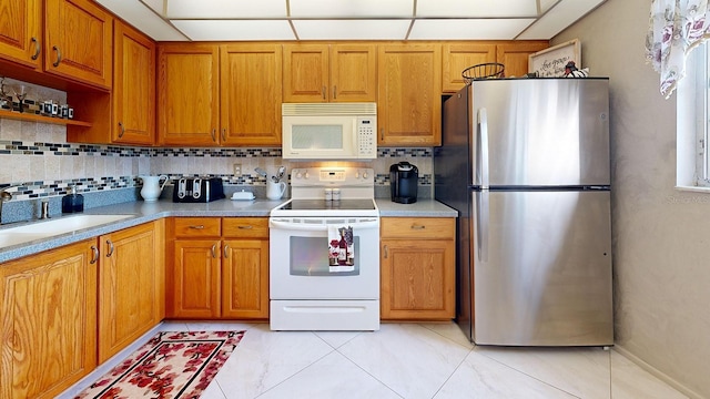 kitchen with white appliances, sink, and backsplash