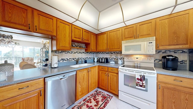 kitchen with white appliances, sink, and backsplash