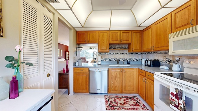 kitchen featuring sink, backsplash, and white appliances