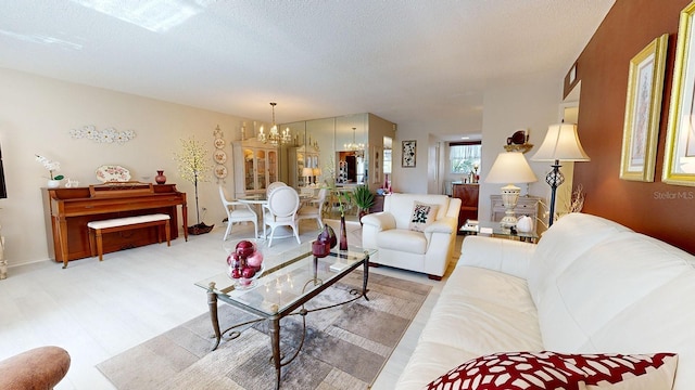 living room with an inviting chandelier and a textured ceiling