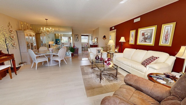 living room with a textured ceiling, a chandelier, and light wood-type flooring